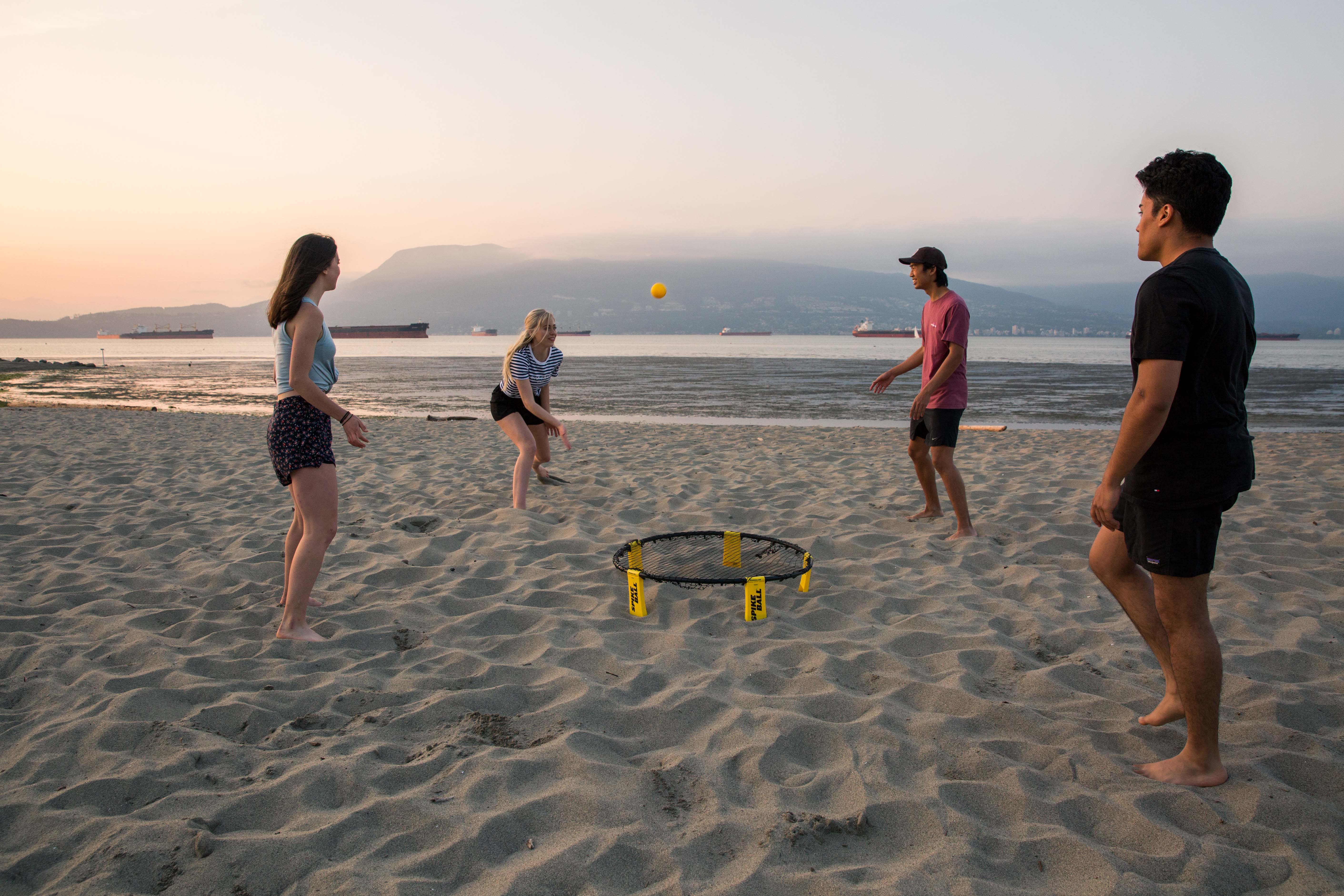Friends at Kitsilano Beach playing Spikeball