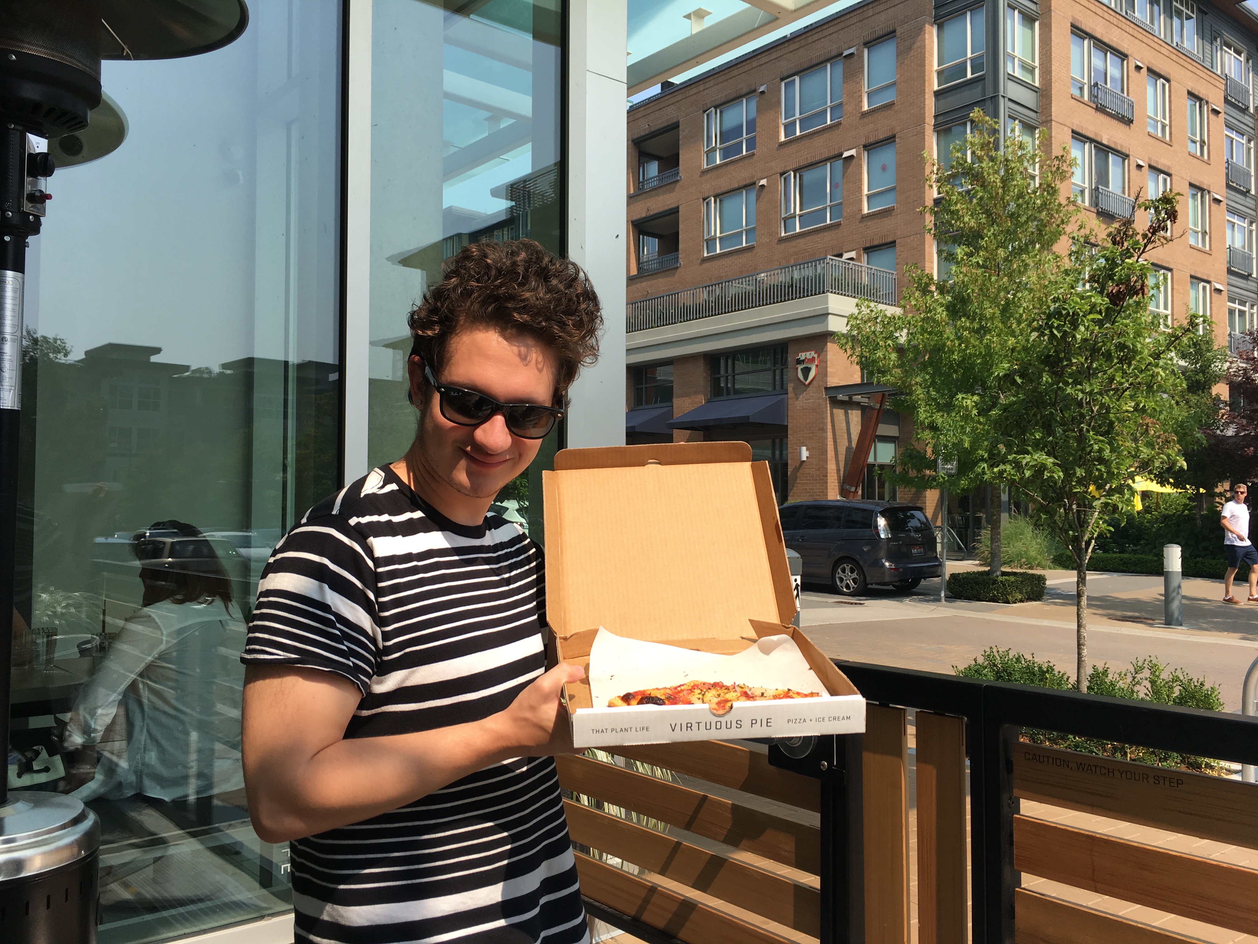 derrick holding a pizza