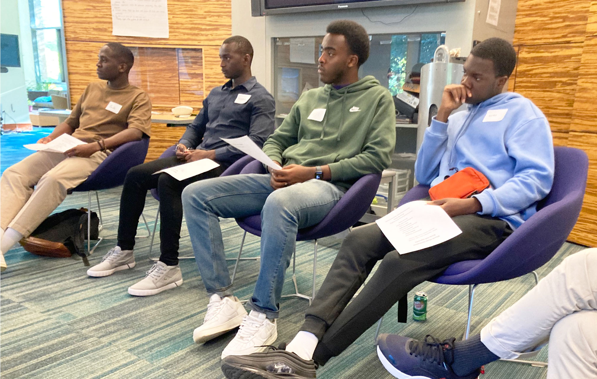 4 Black male students sitting at the first gathering for the Black Male Initiative