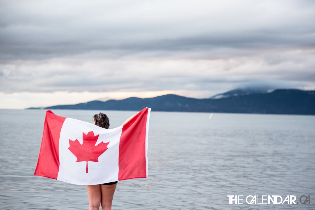 students holding a Canadian flag on the beach
