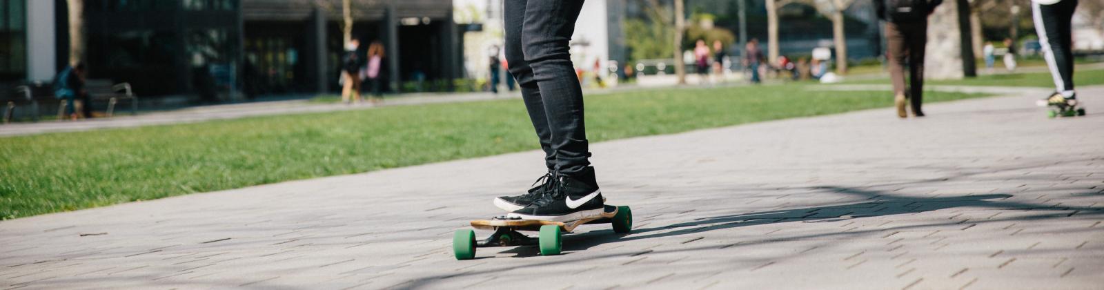 Student skateboarding through UBC campus