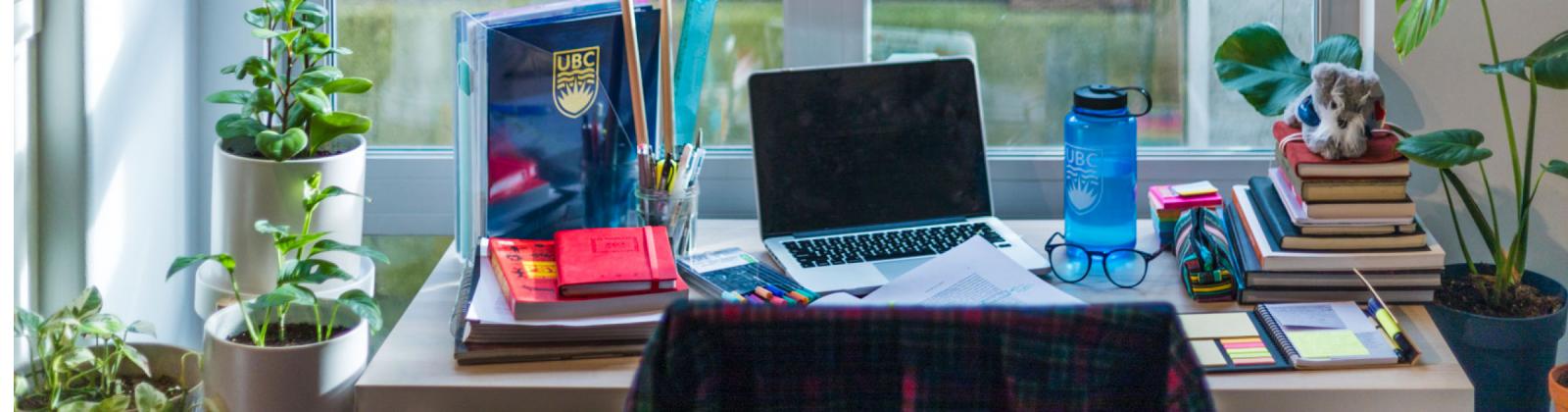 A student's desk with laptop and books