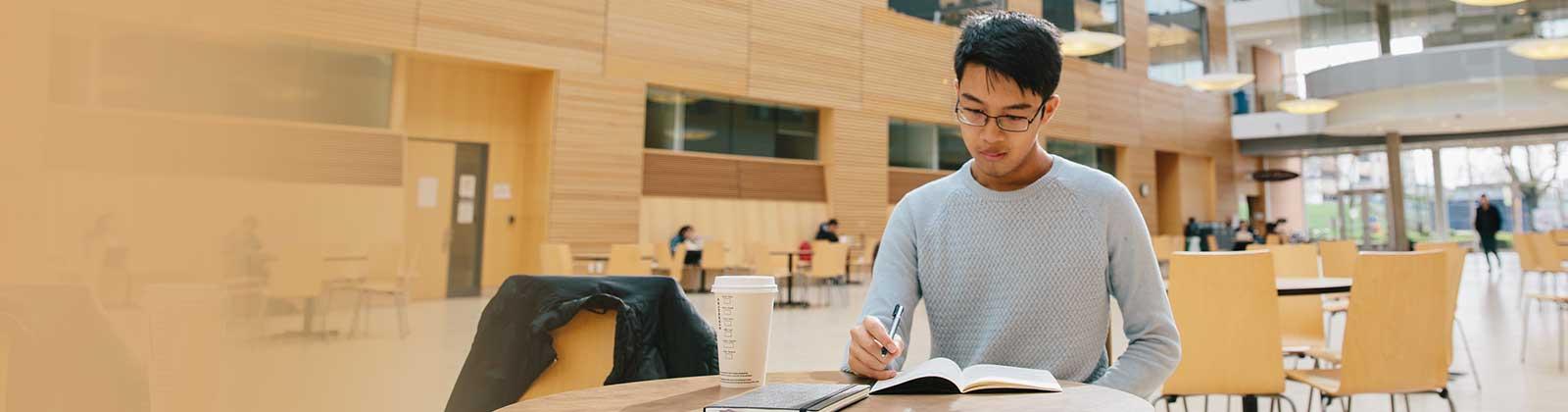 A student studying at a table in the UBC Life Sciences Centre
