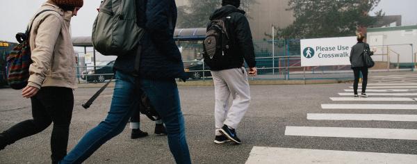 Students stepping onto the crosswalk at the bus loop