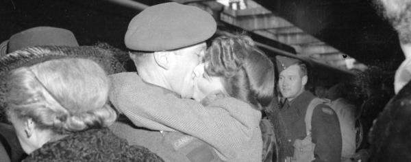 Couple kissing at the train station during WWII