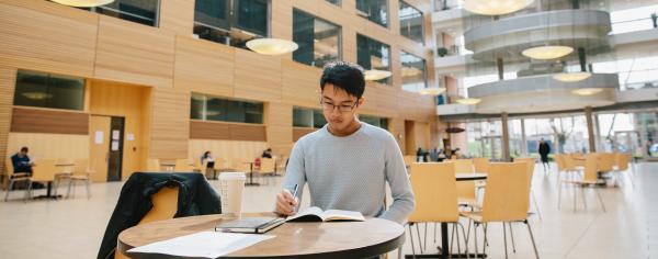 A student studying at a table in the UBC Life Sciences Centre