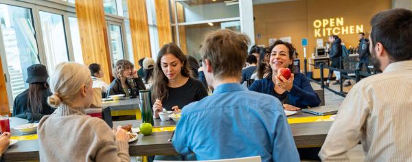 A group of students eating lunch together in the cafeteria at Open Kitchen