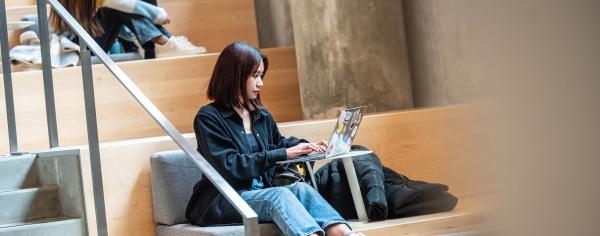 A student working on her laptop in qʷta:yθən leləm̓ (Sturgeon House Residence)