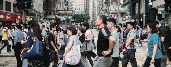 A swarm of people crossing the street in Hong Kong