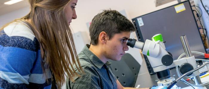 Two UBC students looking at a lab specimen under a microscope