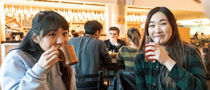 Two UBC students drinking alcohol in a pub setting
