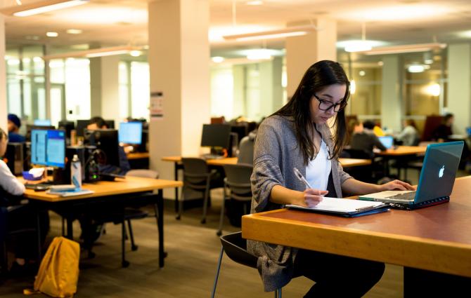 A student proofreading their work in a study space at UBC