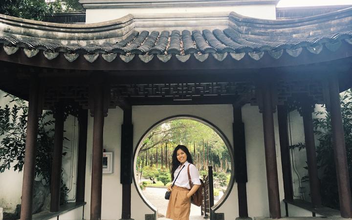 Sara posing in front of a circular door in Asia