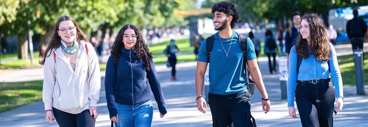 Four UBC students walk down Main Mall on the UBC Vancouver campus